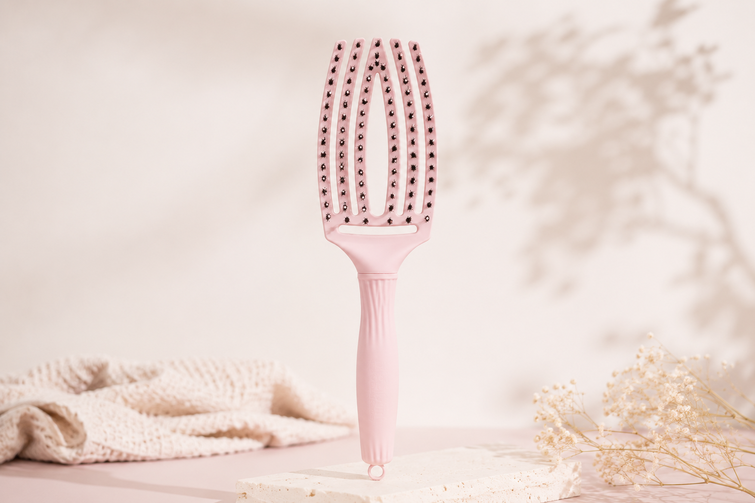 Olivia Garden Fingerbrush Combo Medium Borstel Brosse Olivia Garden Fingerbrush Combo Medium de couleur rose pastel sur un fond beige minimaliste avec de doux éléments naturels.