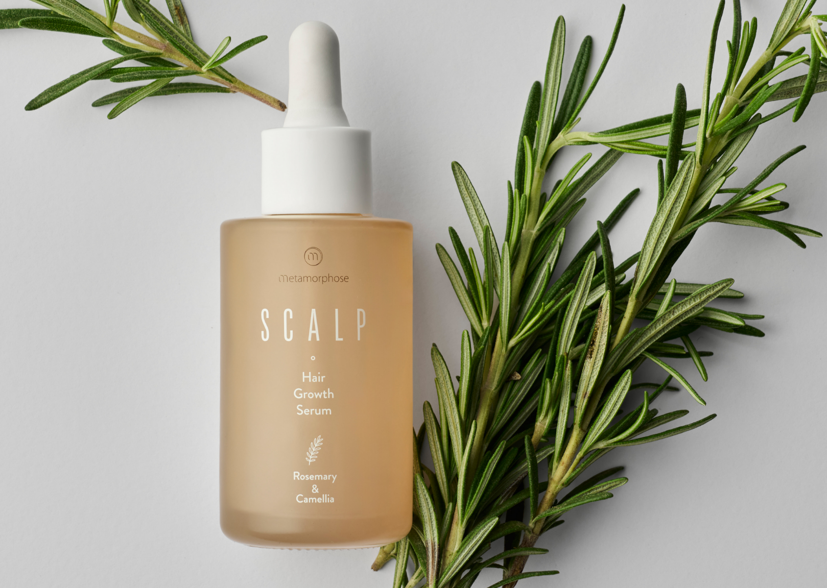 Sérum de croissance capillaire Metamorphose pour stimuler la pousse et des cheveux plus denses Sérum de croissance capillaire Metamorphose avec des branches vertes en arrière-plan